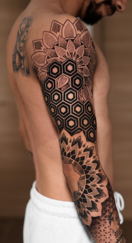 Tatuaje geométrico de mandala en el brazo