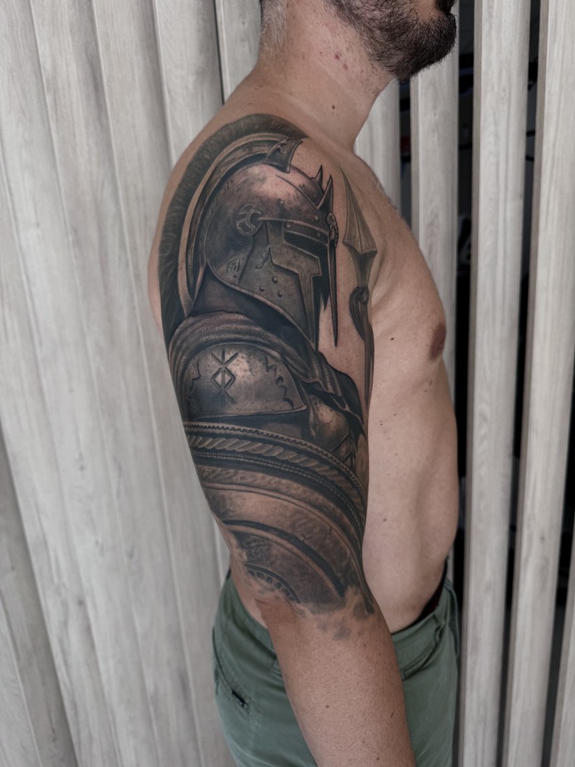 Tatuaje de realismo de un guerrero con armadura en el brazo